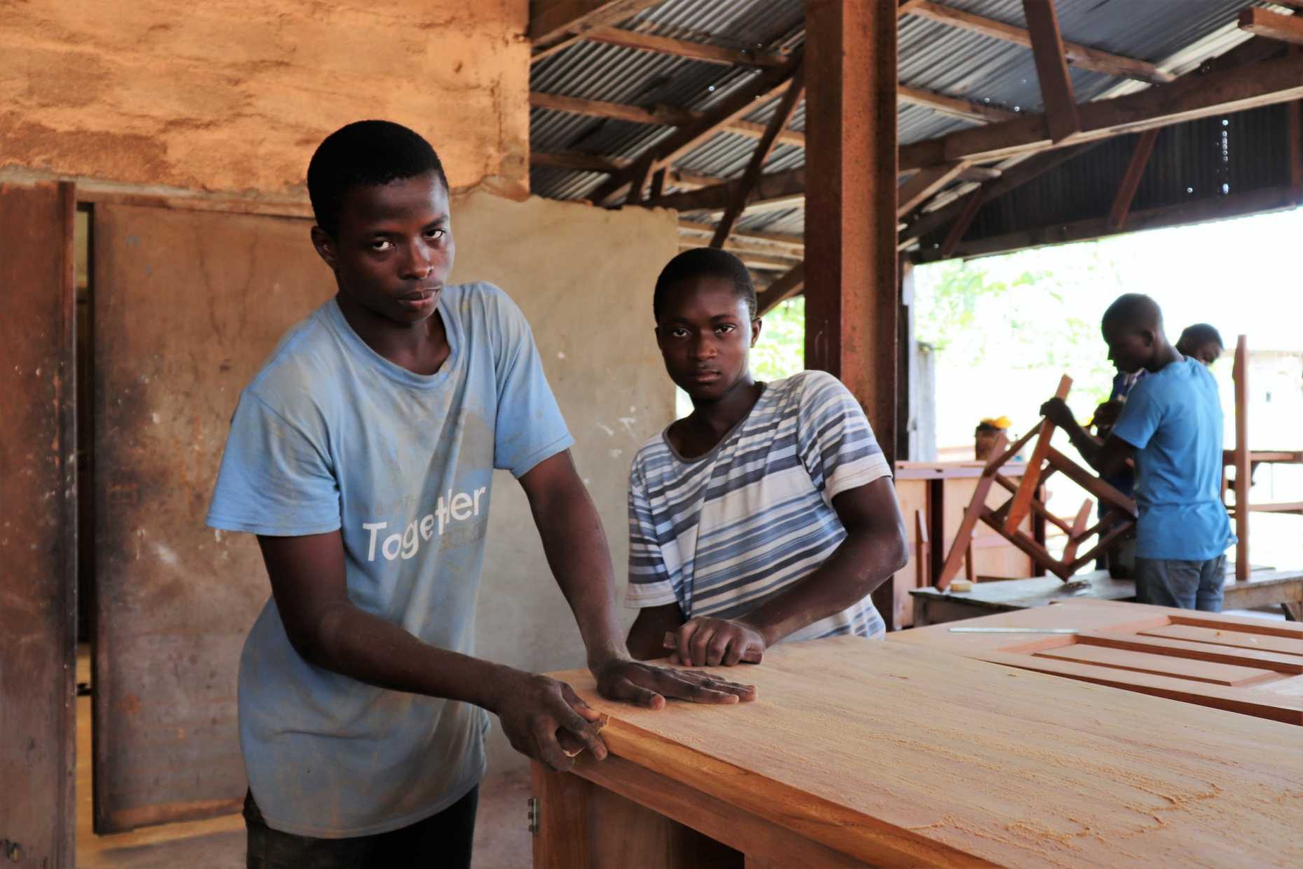 Two young apprentices working on a wooden table