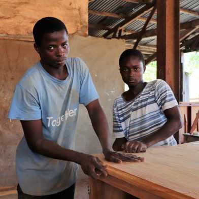 Two young apprentices working on a wooden table