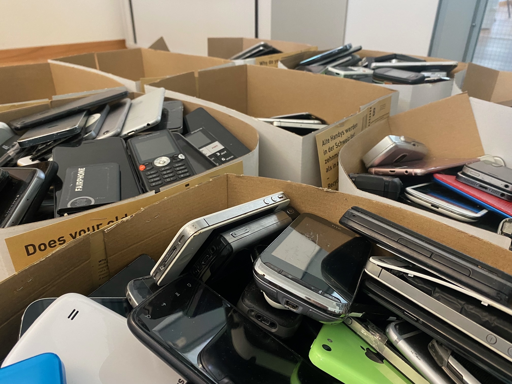 Several boxes full of old smartphones.