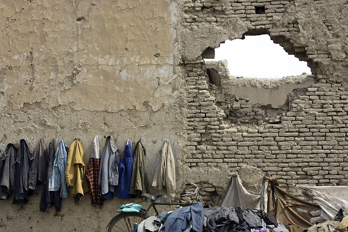 Afghan students' jackets hanging on a destroyed wall